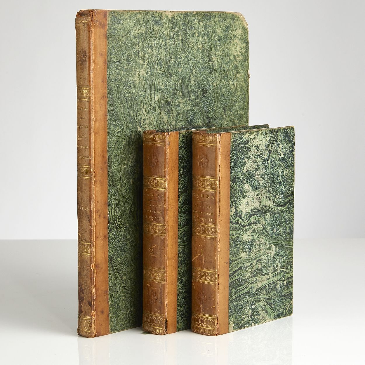 Voyage dans la Russie Méridionale, et particulièrement dans les provinces situées au-delà du Caucase, fait depuis 1820 jusqu`en 1824; Volume I-II in 8vo + Atlas in Folio (331 x 252 mm). Paris, C. J. Trouvé, 1826. Text volumes : (4) + IX + 444; (4) + 480 pp. 4 folding maps, one coloured in outline. 1 folding table. Text with occasional spotting. Atlas volume : 60 lithographic and engraved plates, of which 34 hand-coloured, one plate foxed and with tear. Uniformily bound in contemporary half calf. Gilt spines. Upper joints partly cracked. Bookplate (Gösta Nobel). Stamp with barionial crown and monogram G S on first fly-leafs. Complete, with the rare atlas volume.